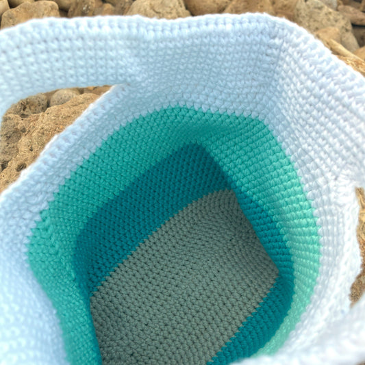 Close-up of a textured bowl with gradient colors on a pebbly background