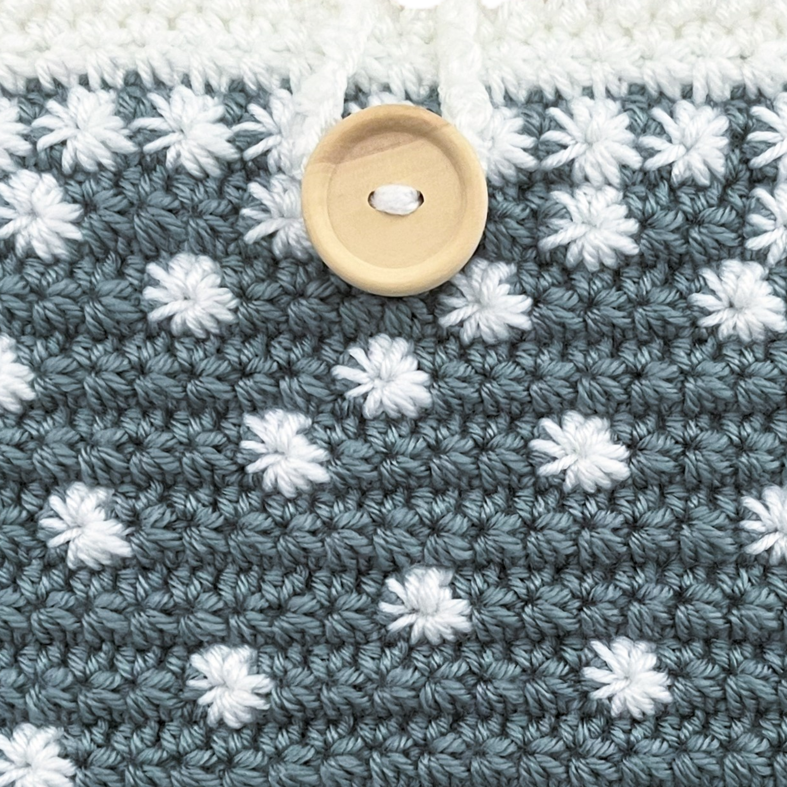 Crocheted clutch bag with white stars pattern on a blue background