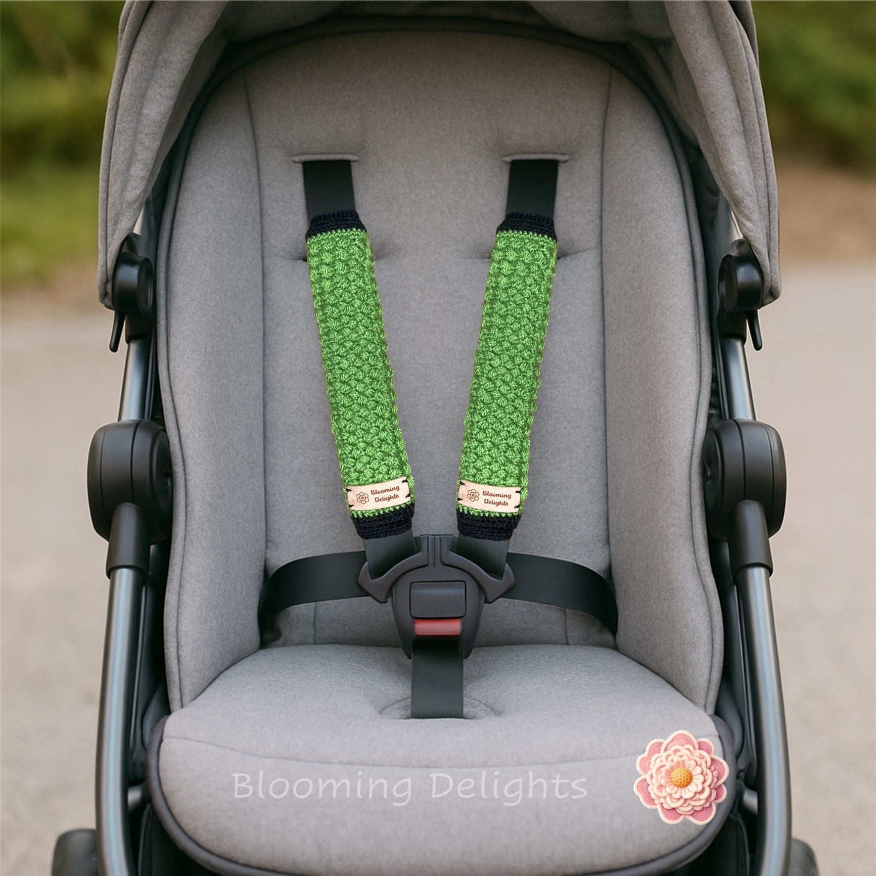 Gray stroller with green and black stroller straps, featuring 'Blooming Delights' branding.