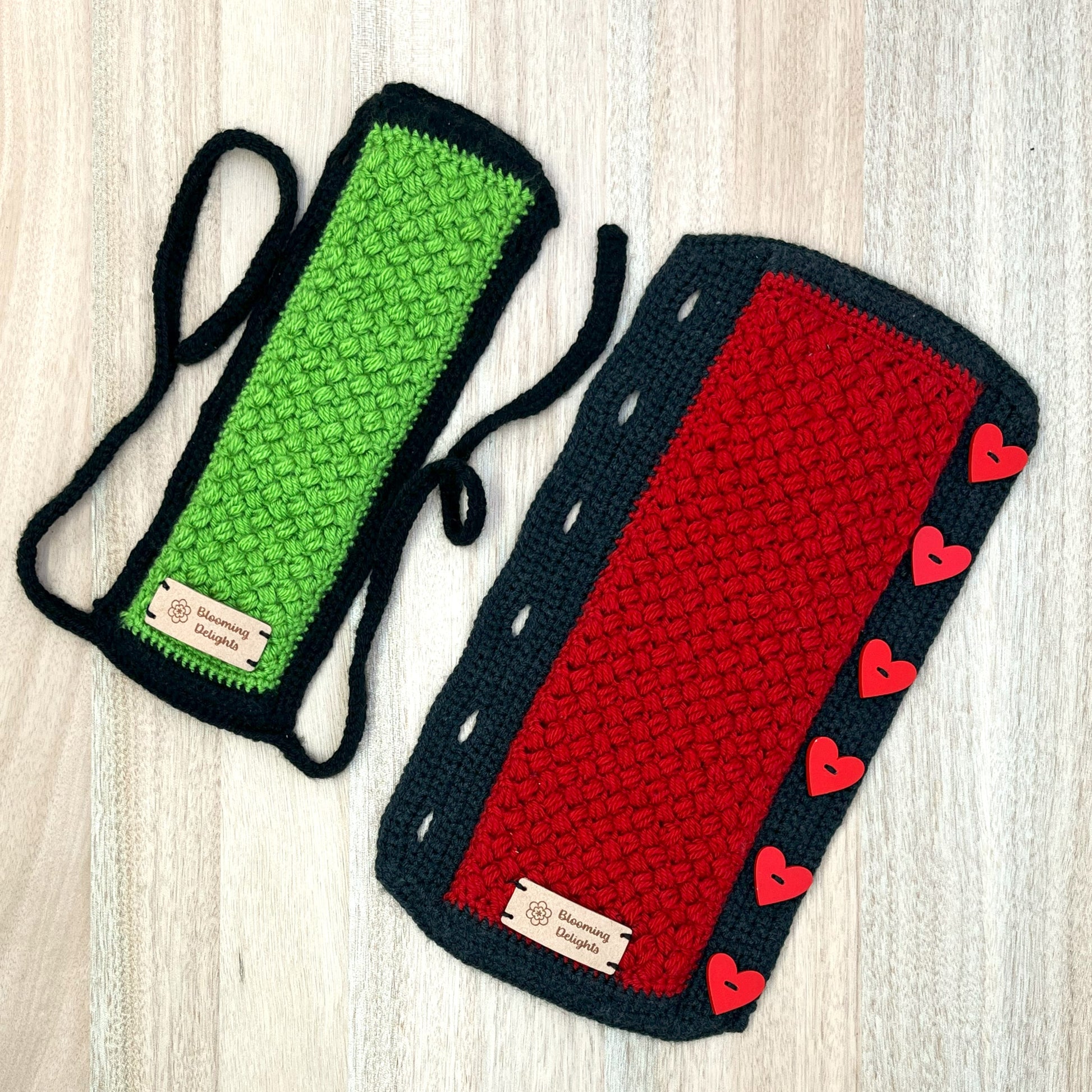 Two crocheted dog toys, one green and one red with heart patterns, on a light wooden surface.